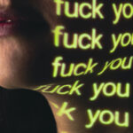 cheek with the words 'fuck you' in light over and over again on them