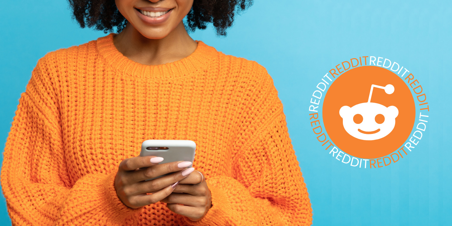black woman holding smart phone next to reddit logo