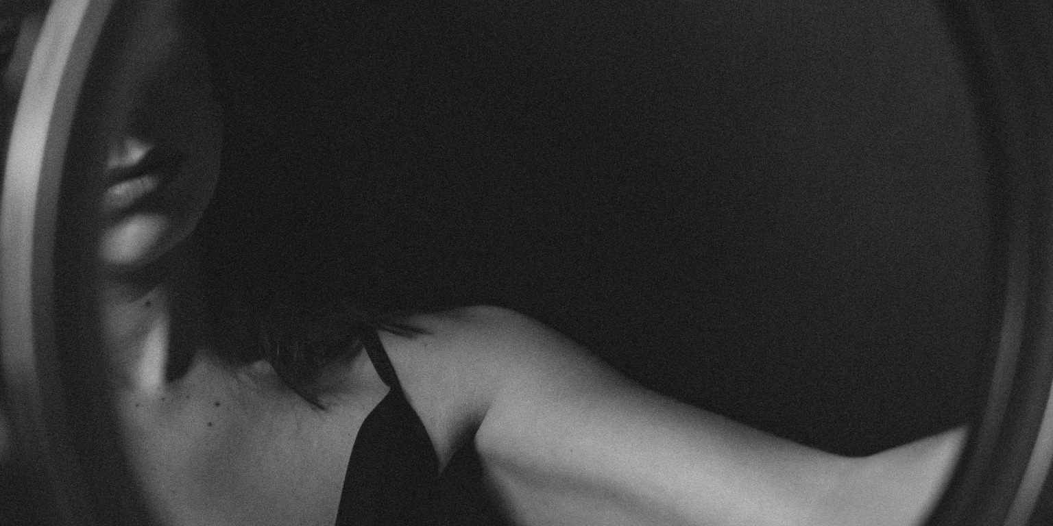 faceless girl looking in mirror black and white
