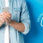 man holding smart phone next to discord logo
