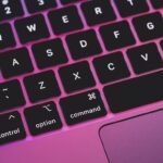 laptop keyboard with pink and purple hue