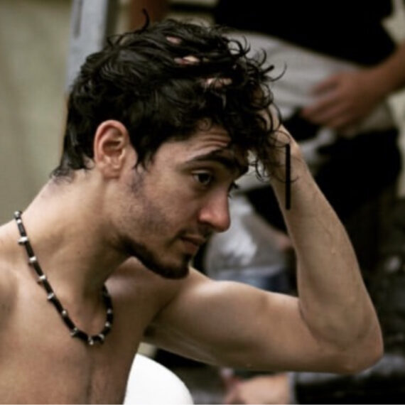 Shirtless man touching his brown hair